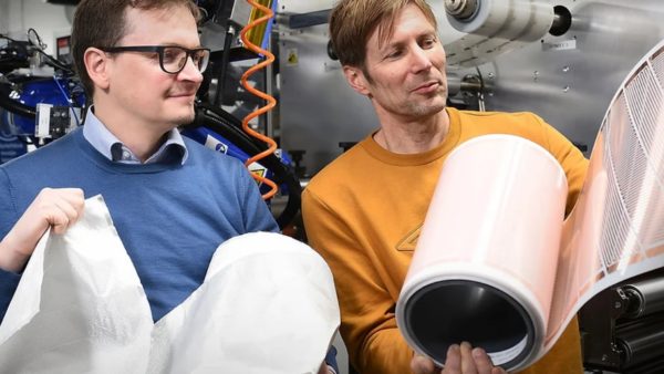 Co-founders Jani-Mikael Kuusisto, left, and Jarno Vehmas show their 0.3mm-thick printed film with tiny heaters, which they say can be integrated into a building’s interior surfaces (Courtesy of The Warming Surfaces Company)